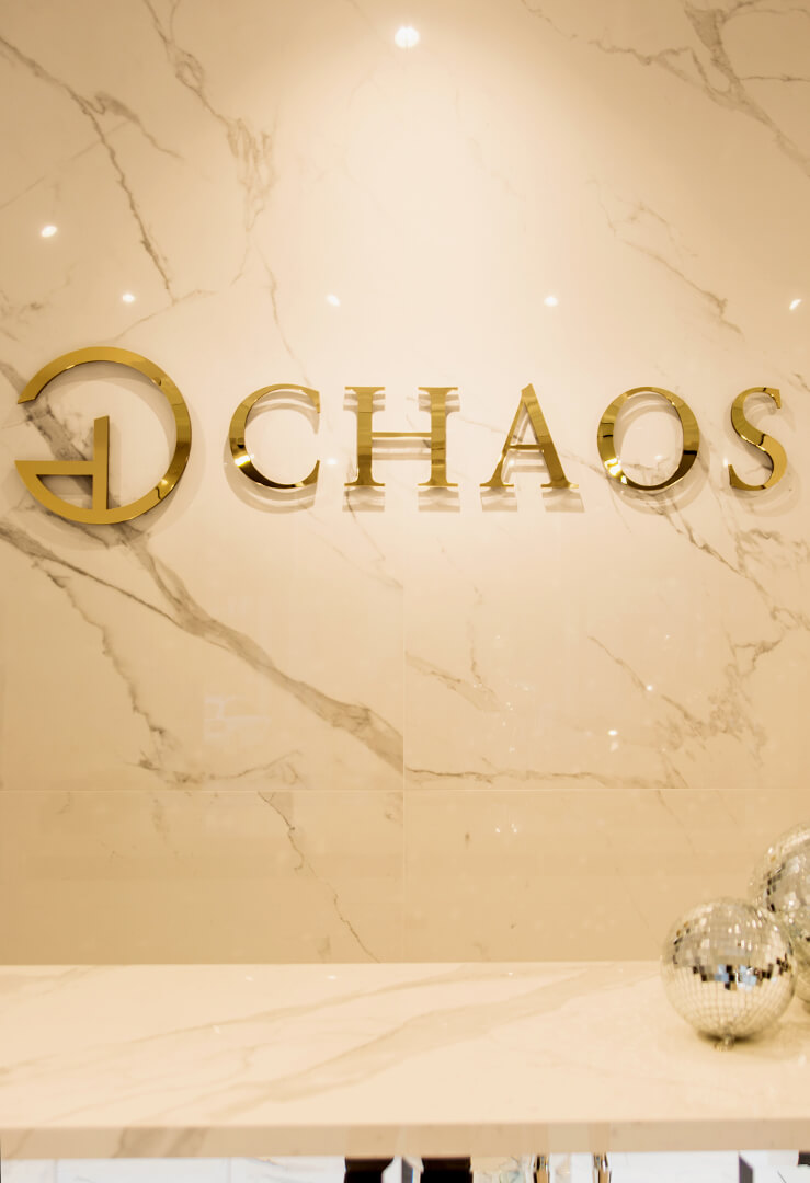 Chaos - gouden logo en 3D ruimtelijke letters van plexiglas op de muur